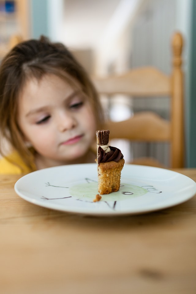 bambina che guarda un cupcake nel piatto