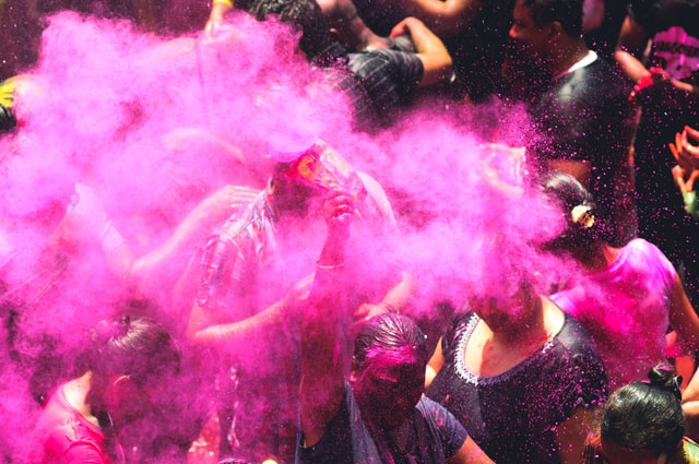 Persone in strada festeggiano con le polveri Holi Color