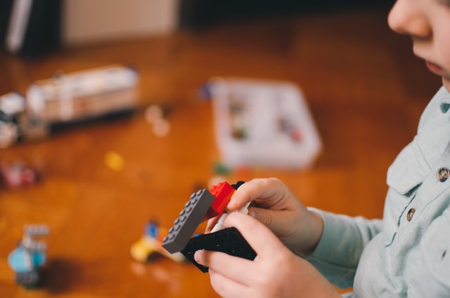 bambino che gioca con dei lego, perfetti regali di compleanno per bambini